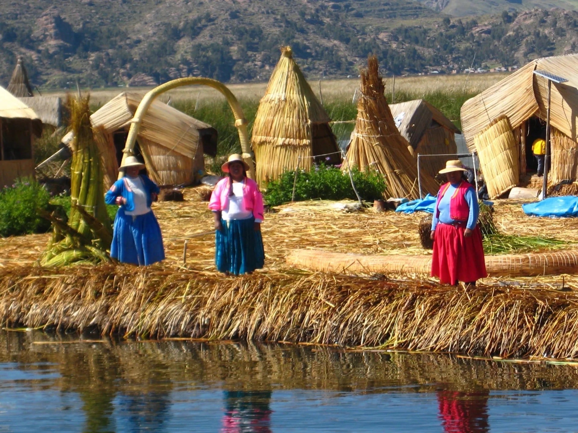 Three Ladies in Front of Straw Huts